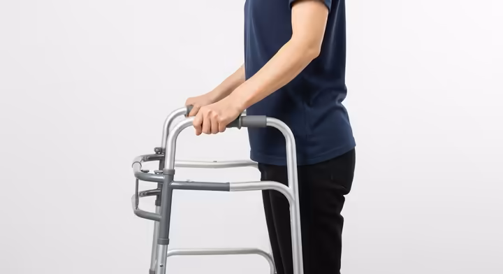 A person demonstrating the correct handle height for a walker, with a slight bend in the elbow.
